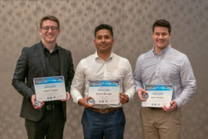 Three young men standing together showing finalist certificates